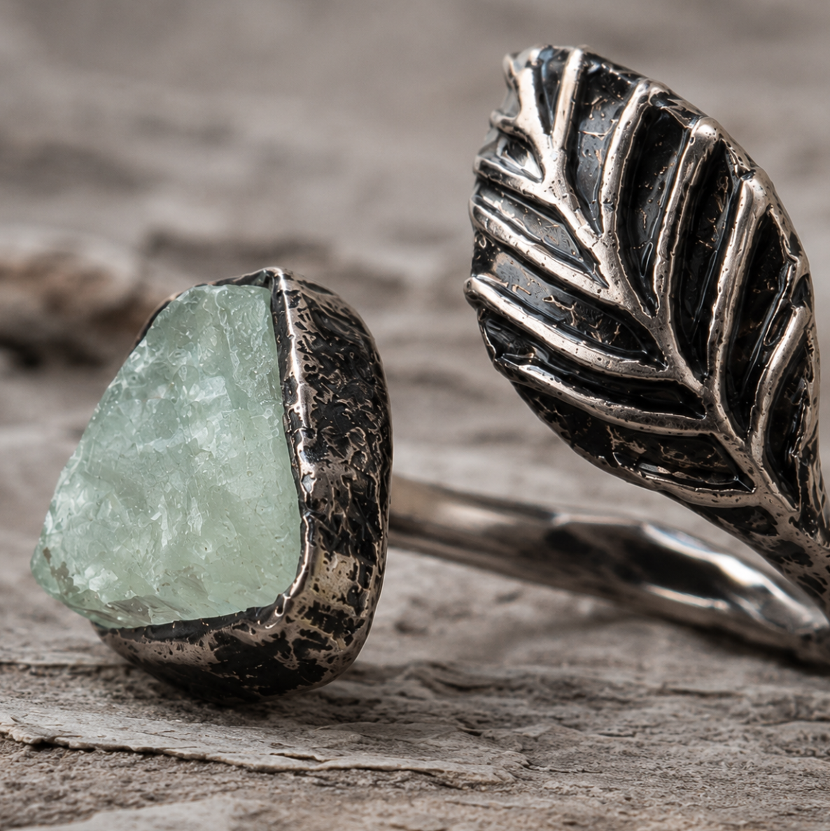 Fluorite feather ring displayed on weathered wood with soft shadows and woodland-inspired styling.
