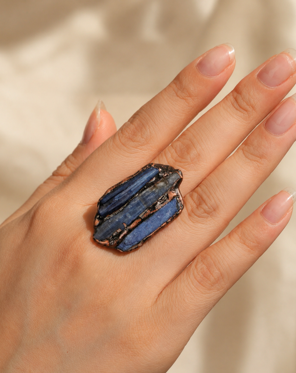 Raw gemstone ring with three uneven blue kyanite stones and an artistic open-band silhouette.