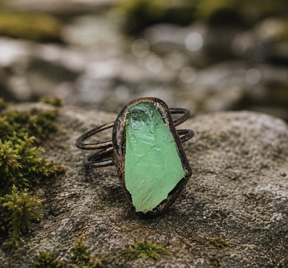 Green gemstone ring with fresh forest tone, irregular stone shape, and sculptural presence.