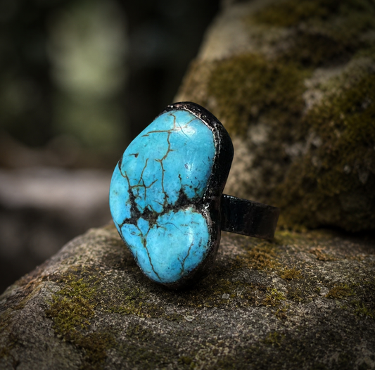 Natural turquoise ring displayed on mossy wood with raw turquoise color and quiet nature-inspired elegance.