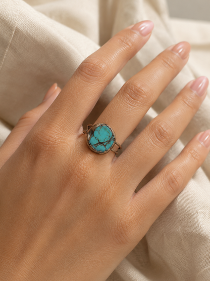 Turquoise statement ring styled on the hand with bold blue gemstone ring color and organic texture.