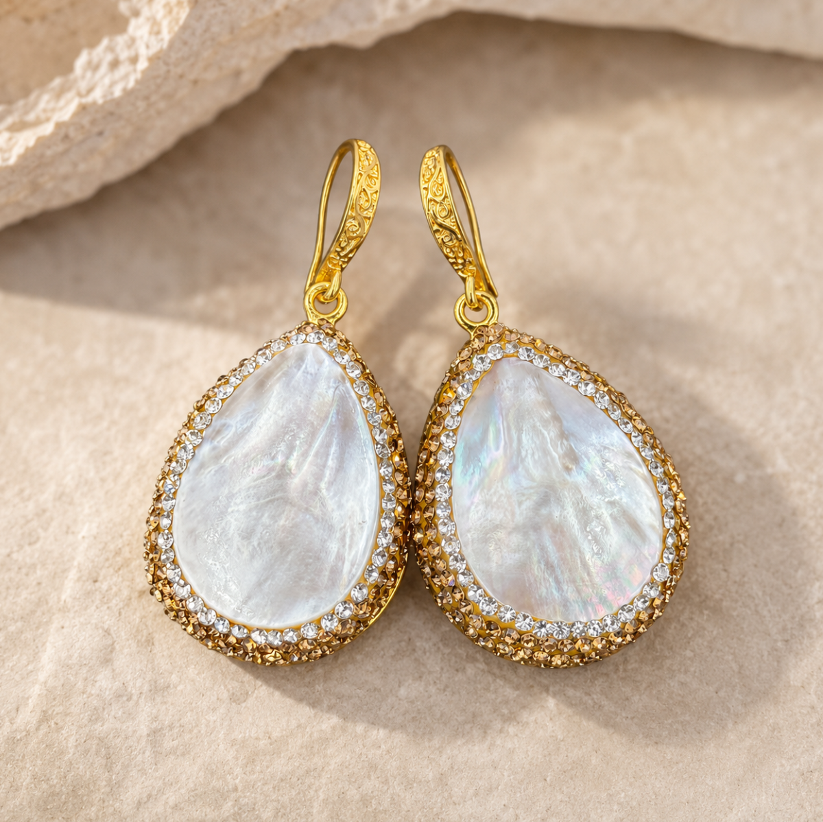 Shell drop earrings with mother-of-pearl glow, natural texture, and refined coastal jewelry styling.
