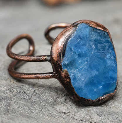 Lake blue gemstone ring with natural mineral texture, organic setting, and quiet feminine elegance.
