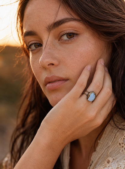 Natural aquamarine ring styled on the hand with warm coastal light and relaxed feminine elegance.