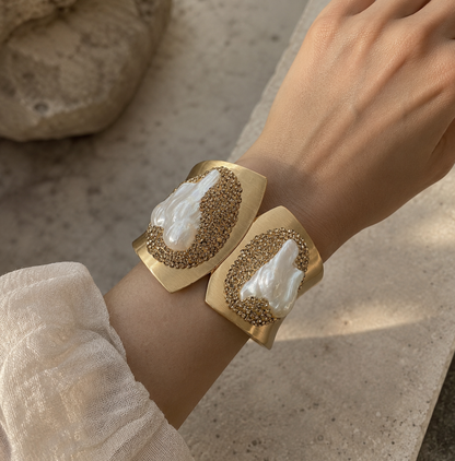 Baroque pearl bracelet with sculptural gold cuff design, natural pearl texture, and soft luxury styling.