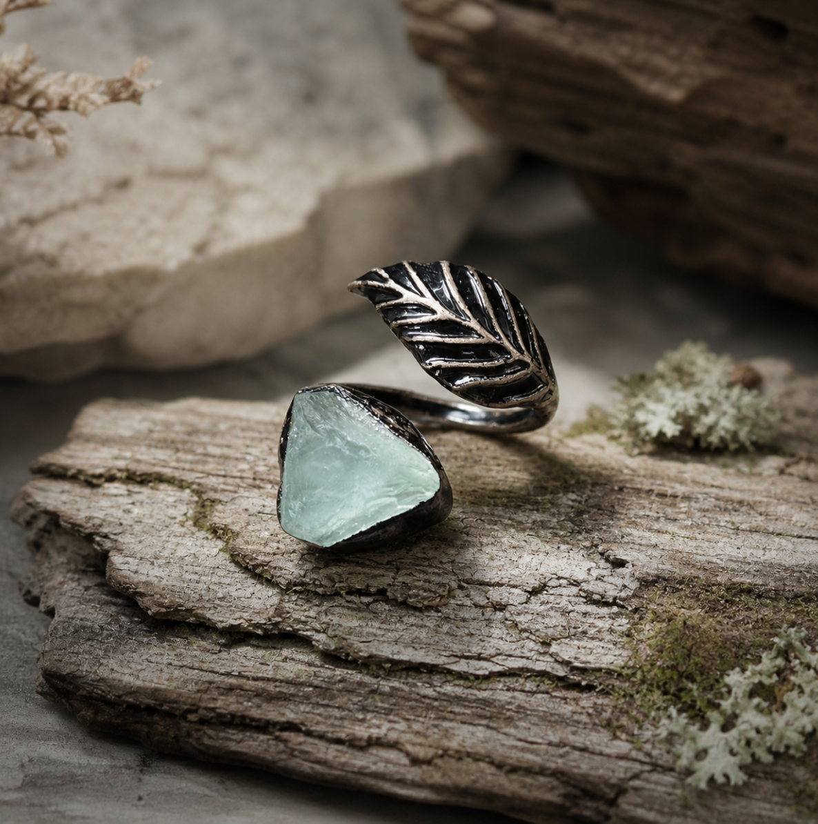Green fluorite ring with feather shaped ring design, raw crystal texture, and quiet botanical mood.
