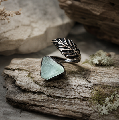 Green fluorite ring with feather shaped ring design, raw crystal texture, and quiet botanical mood.