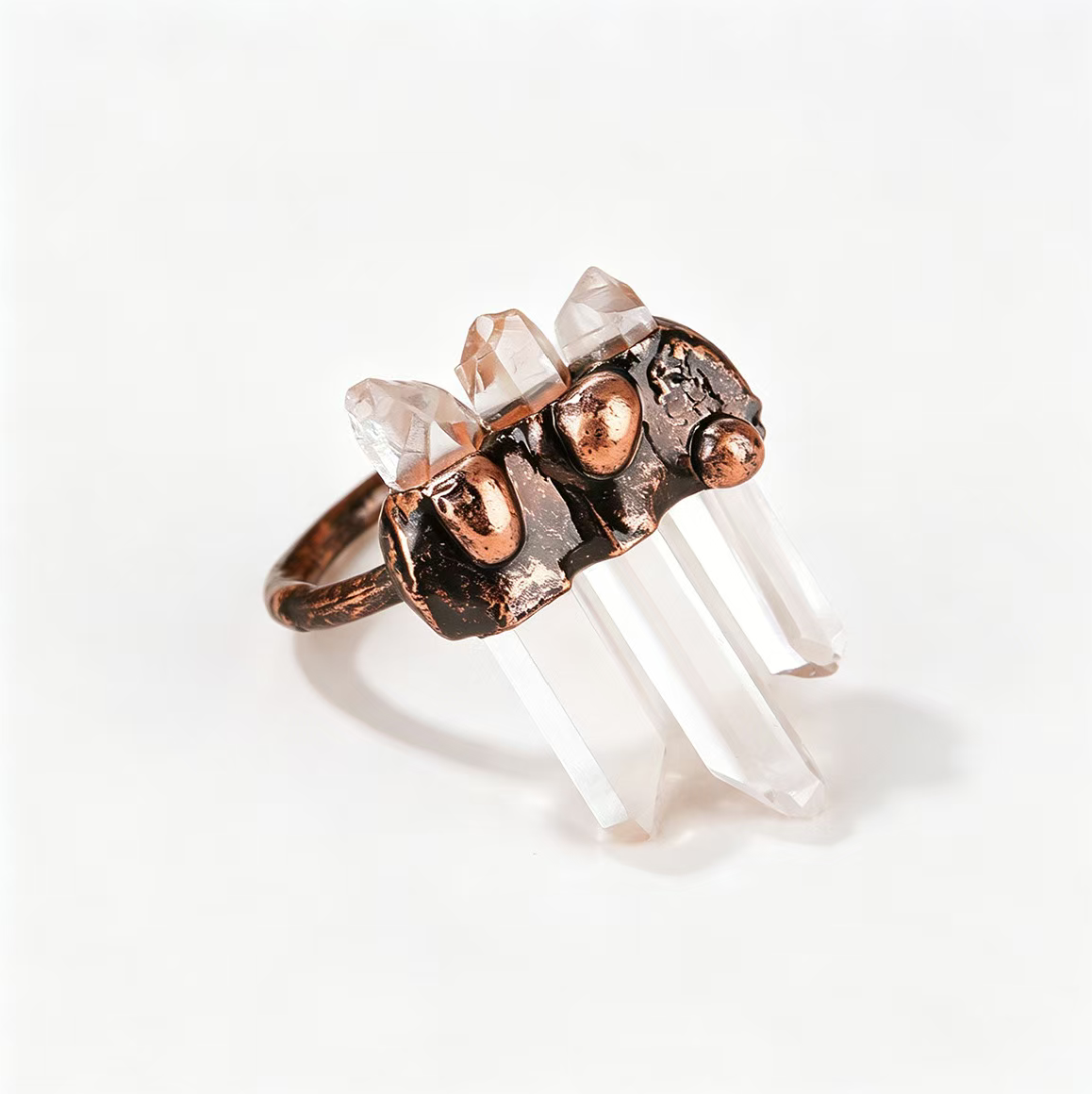 Artistic raw crystal ring featuring vertical quartz towers and a sculptural handcrafted copper band.