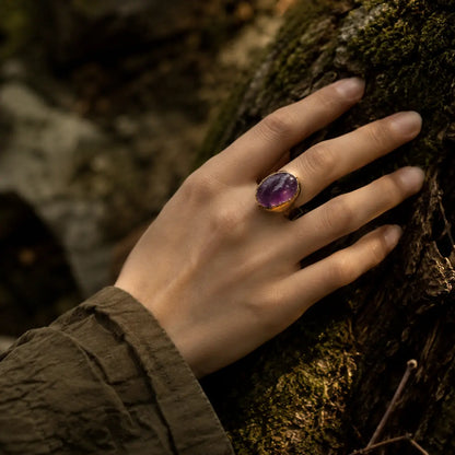 Amethyst ring styled on the hand with soft purple glow, natural texture, and refined everyday elegance.