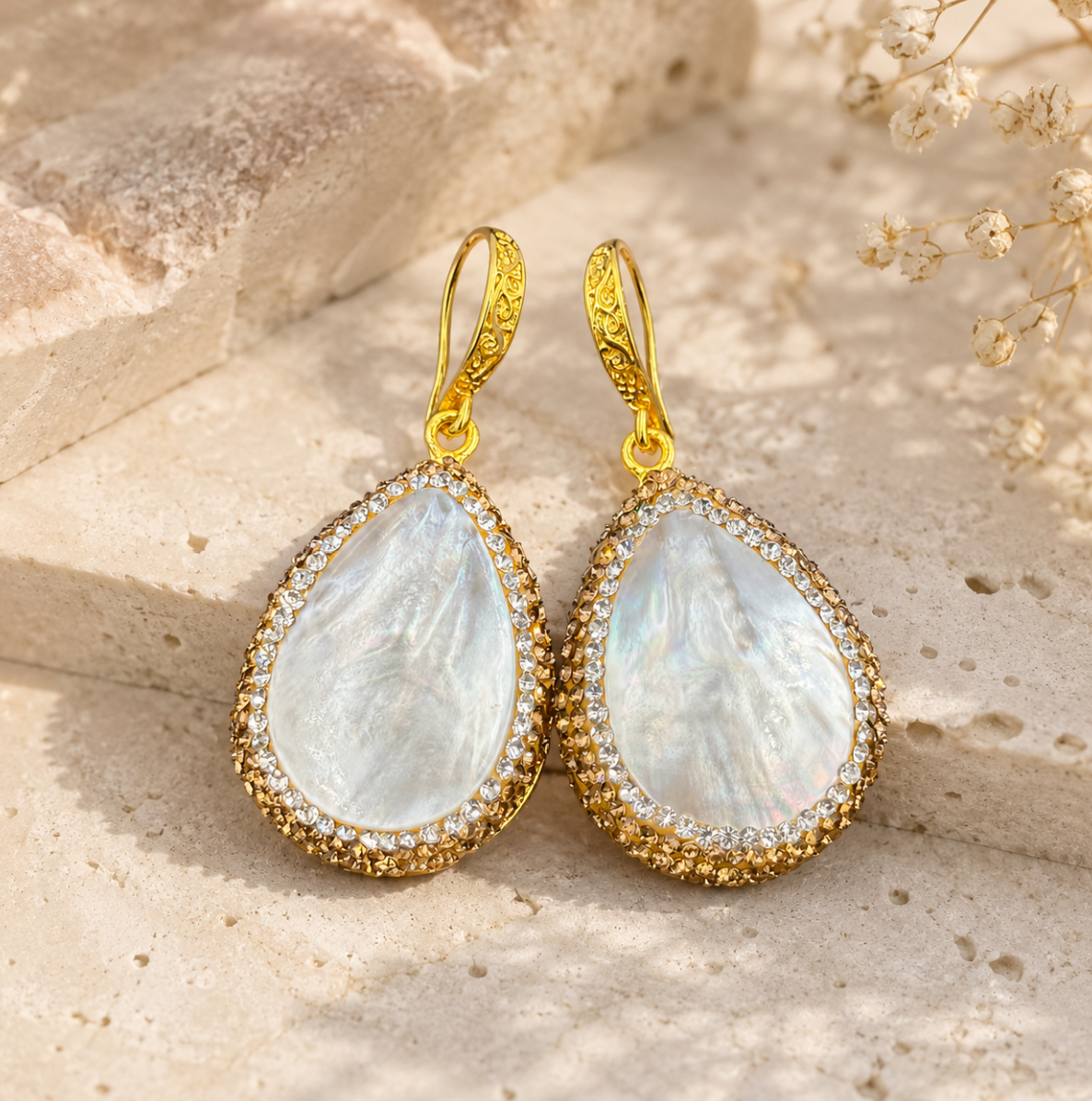 Pearl shell earrings with luminous shell texture, pearl accents, and delicate gold-tone details.