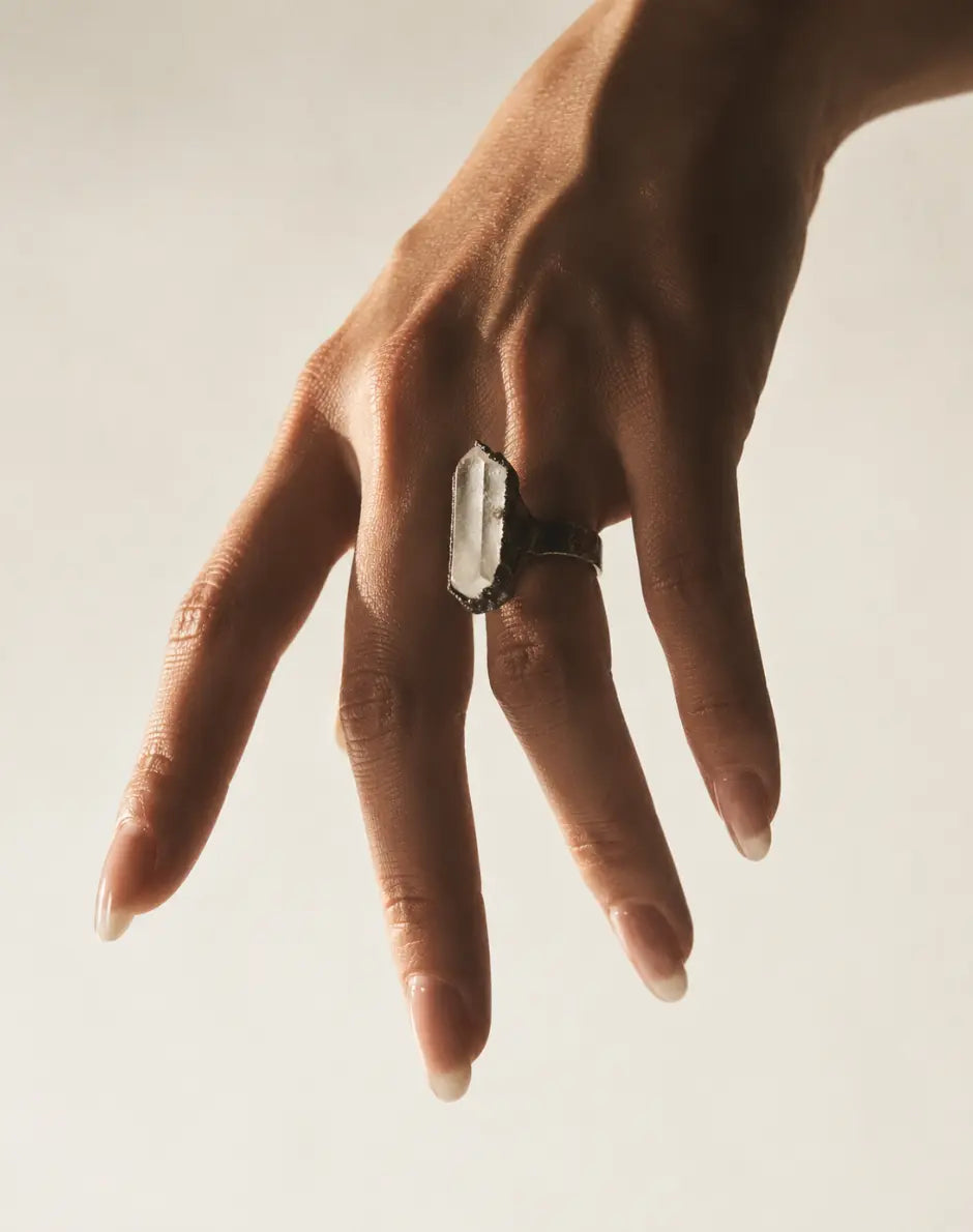 Clear quartz ring featuring a tall crystal point, organic texture, and refined minimalist styling.