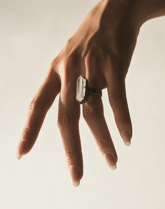 Clear quartz ring featuring a tall crystal point, organic texture, and refined minimalist styling.